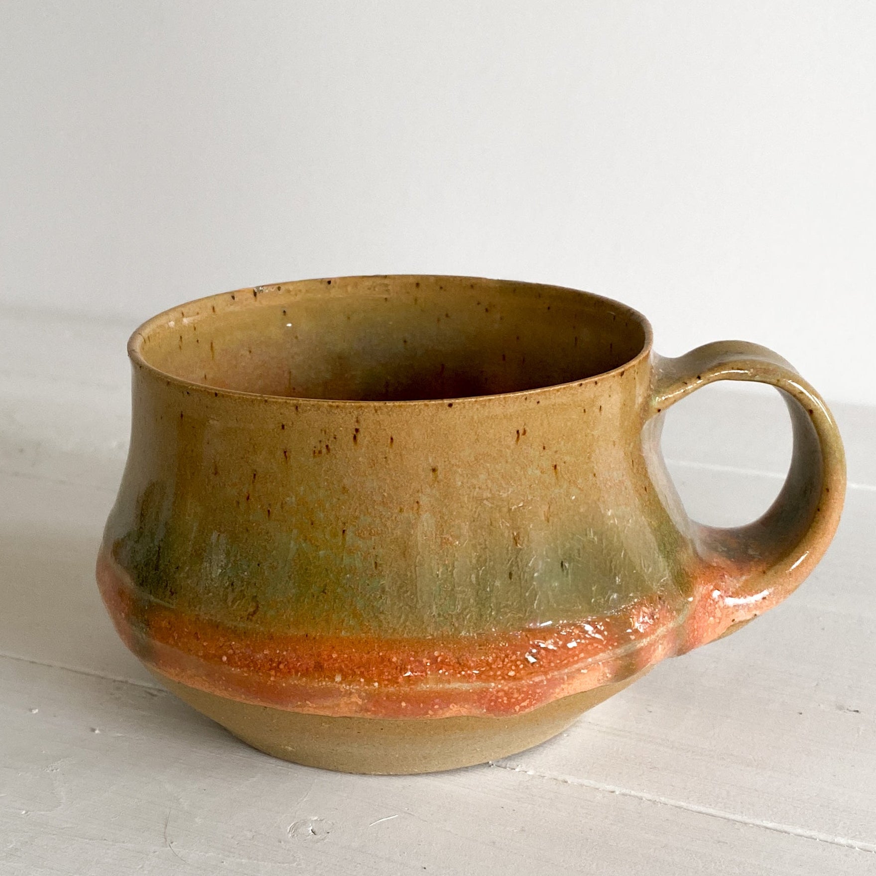 Ceramic mug with a handle on a white surface