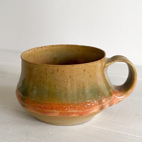 Ceramic mug with a handle on a white surface