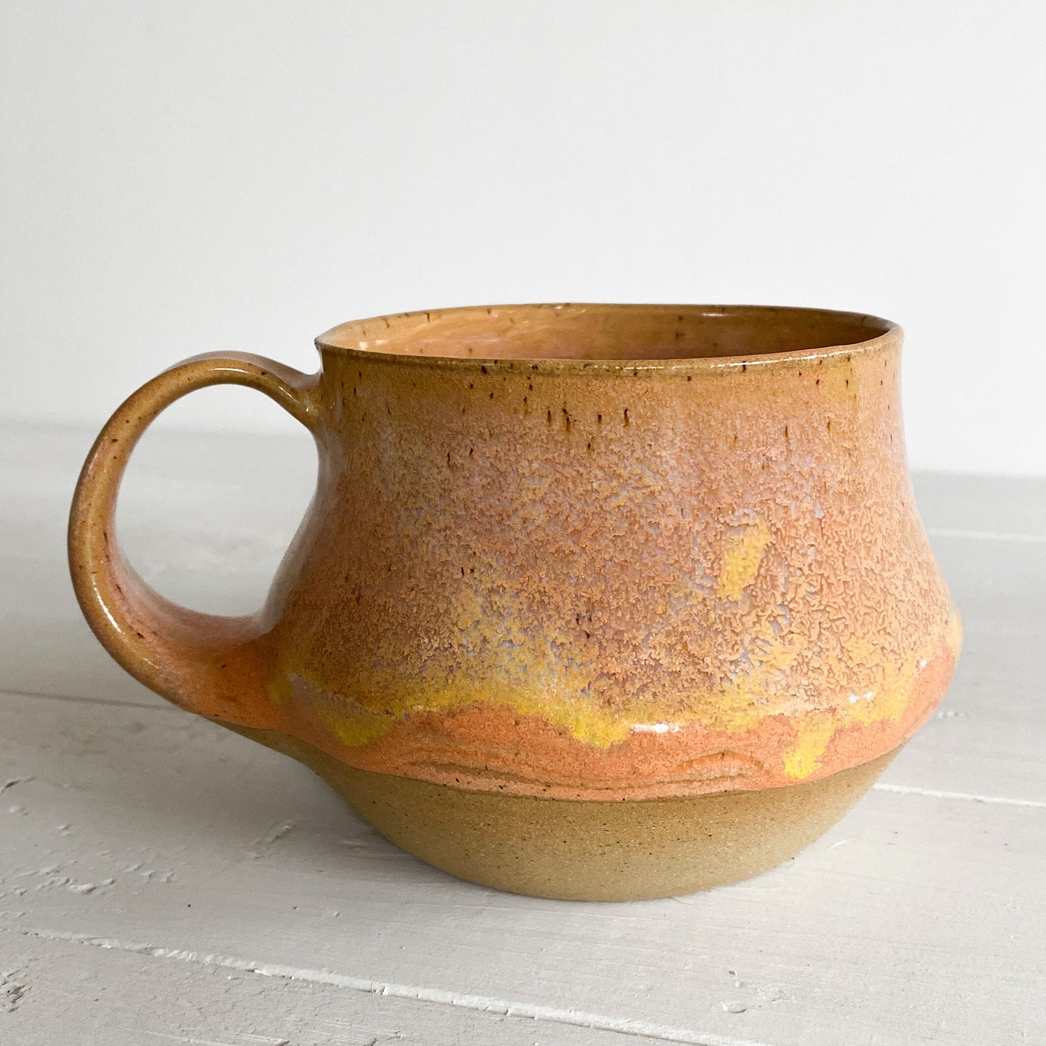 Ceramic mug with a gradient finish on a light gray surface