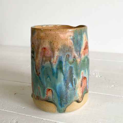 Ceramic mug with multicolored glaze on a white surface