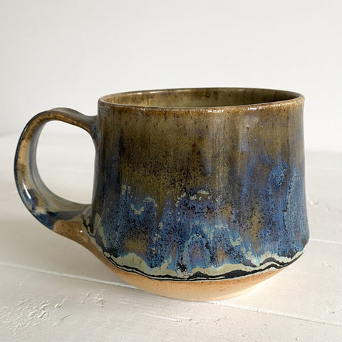 Ceramic mug with blue and brown glaze on a white surface