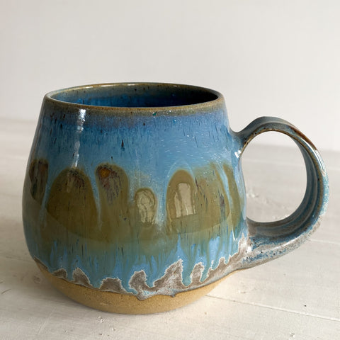 Blue ceramic mug with a textured surface on a light background