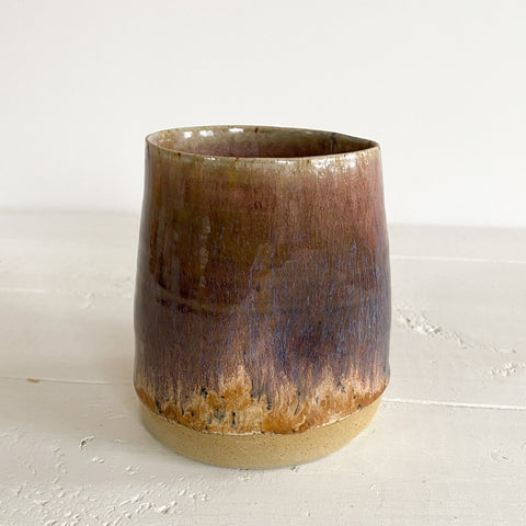Brown ceramic cup on a light wooden surface