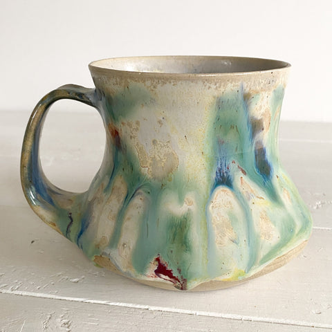 Ceramic mug with multicolored glaze on a white surface