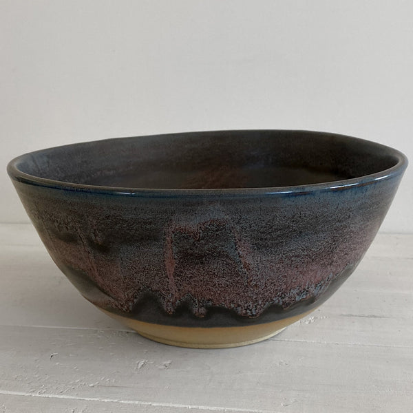Black ceramic bowl on a light gray surface with a white background