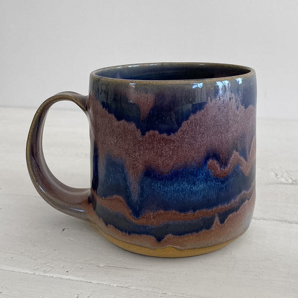 Ceramic mug with blue and brown glaze on a white surface