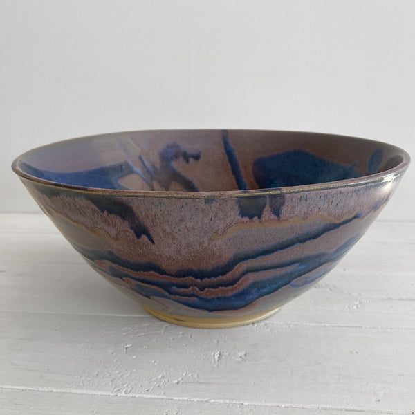 Ceramic bowl with blue and brown glaze on a white surface