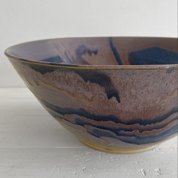 Ceramic bowl with brown and blue glaze on a white background