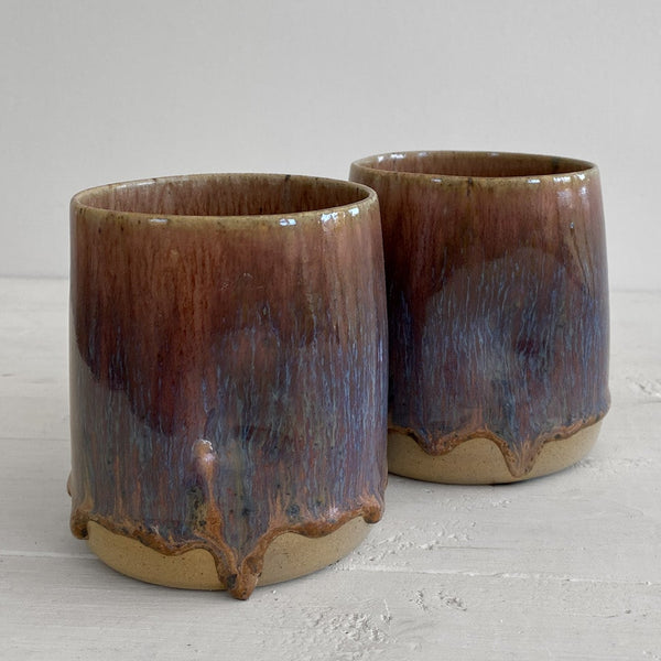 Two ceramic cups with a gradient finish on a light gray background