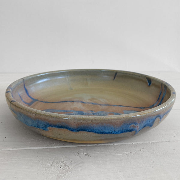 Ceramic bowl with blue and brown glaze on a white surface
