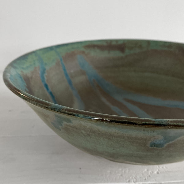 Ceramic bowl with multicolored glaze on a white surface