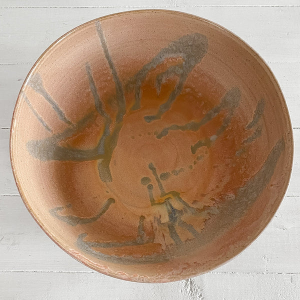 Ceramic bowl with abstract design on a white wooden surface