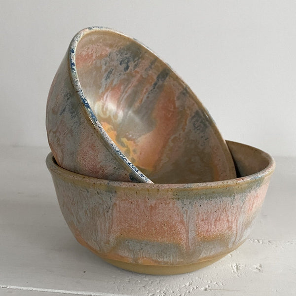 Two ceramic bowls with a textured surface on a light gray background