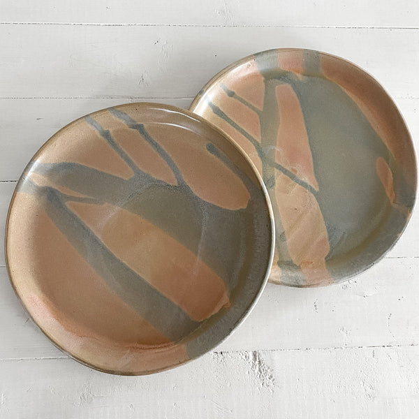 Two ceramic plates with abstract patterns on a white surface
